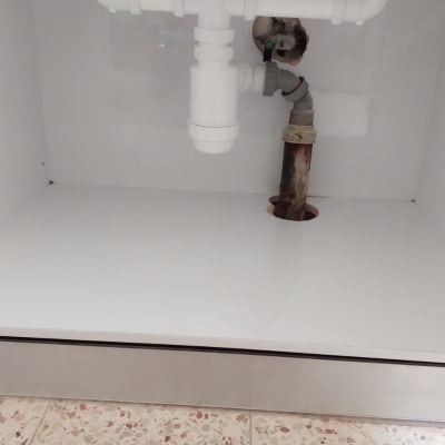 צנרת פלסטיק לבנה מתחת לכיור מטבח