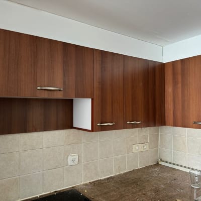 ארונות מטבח עץ עם ידיות מתכת מעל משטח עבודה