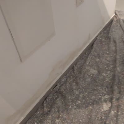 קיר עם סימני צבע ויריעת מגן על הרצפה