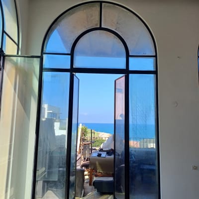 דלתות זכוכית פתוחות עם נוף לים