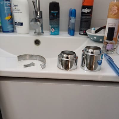 חלקי ברז מונחים על כיור בחדר אמבטיה