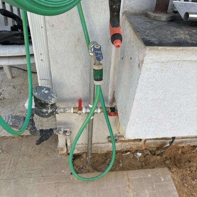 צינור ירוק מחובר לברז עם ידית אדומה