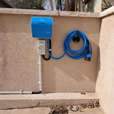 עמדת טעינה כחולה לרכב חשמלי על קיר חיצוני