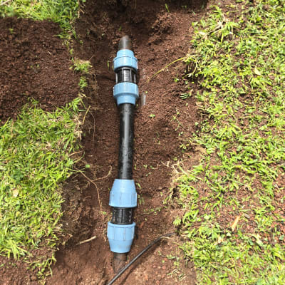 צינור פלסטיק עם מחברים כחולים באדמה
