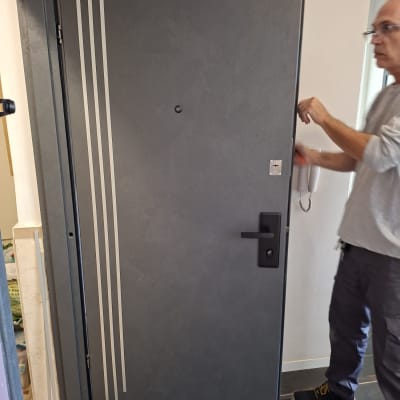 דלת עם ציפוי חדש ואדם מתקין
