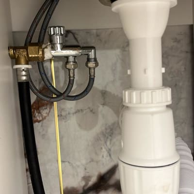 צנרת מתחת לכיור עם חיבורים וברזים