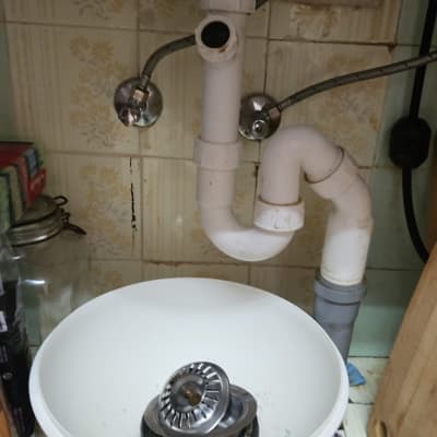 כיור עם צנרת וכלי עבודה בתחום האינסטלציה