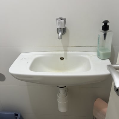 כיור עם ברז ומתקן סבון בחדר אמבטיה