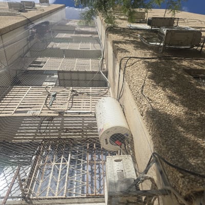 רשת נגד יונים מותקנת על גבי מסתור כביסה בבניין מגורים
