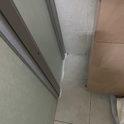 פינה של מקלחת עם אריחים ודלת זכוכית