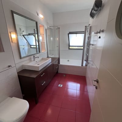 חדר אמבטיה עם כיור, מראה ורצפה אדומה