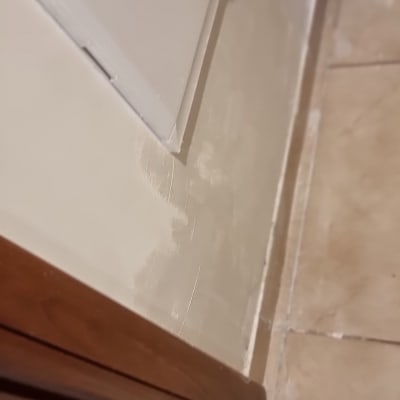 קיר עם תיקוני טיח ליד דלת עץ