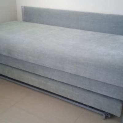 מיטה מרופדת בבד אפור עם ראש מיטה תואם