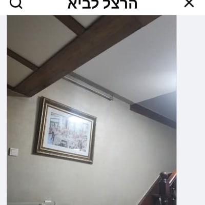 תמונה ממוסגרת על קיר בסלון עם תקרה מעוצבת