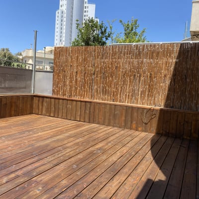 דק עץ עם גדר במבוק בחצר