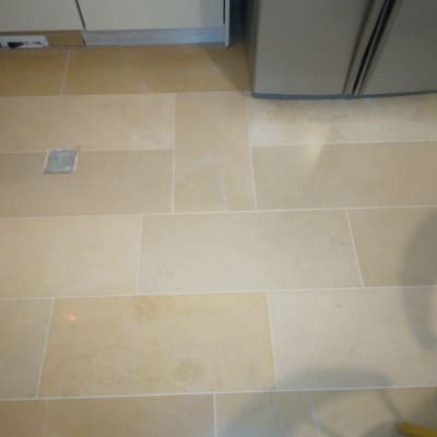 רצפה נקייה עם אריחים בהירים ליד מקרר