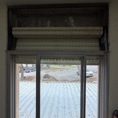 חלון עם תריסים פתוחים ונוף חיצוני