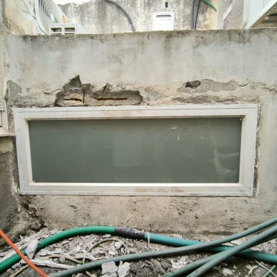 קיר עם חלון קטן, צינורות וחומרי איטום