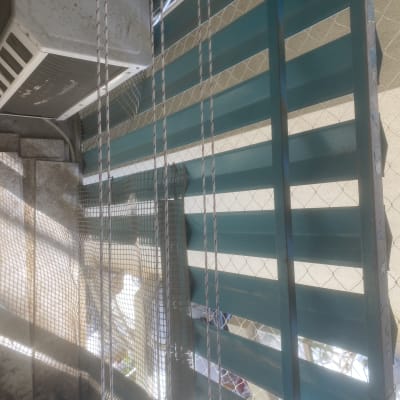 רשת מתכת וחבלים ליד תריסים ירוקים