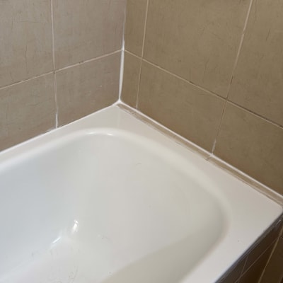 אמבטיה עם אריחים ומחזיק סבון על הקיר