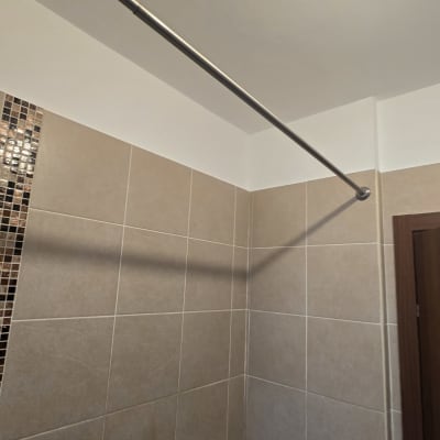 קיר אריחים בחדר אמבטיה עם מוט תלייה