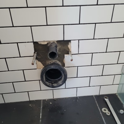 צינור וכלי עבודה על קיר אריחים