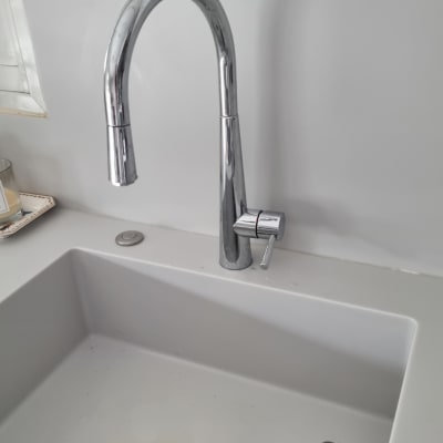 ברז נירוסטה בכיור מטבח עם ספוג ניקוי