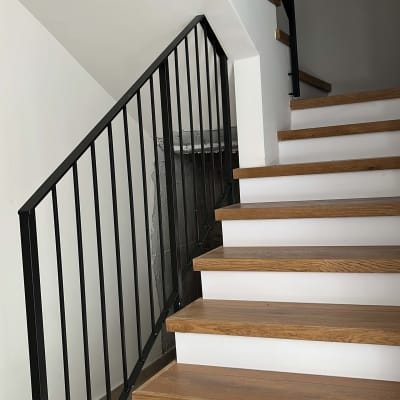 מדרגות עץ נקיות עם מעקה מתכת שחור