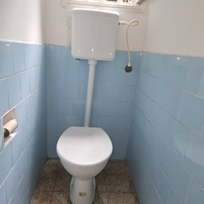 אסלה עם מיכל הדחה בחדר שירותים קטן