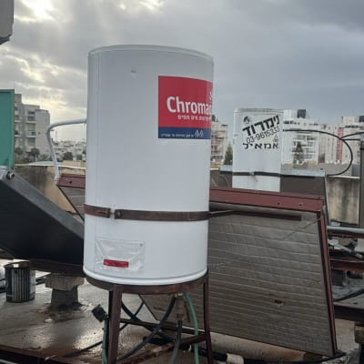 דוד שמש על גג עם רקע של שמיים מעוננים