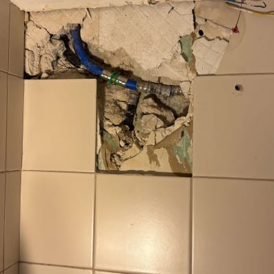 צינור כחול חשוף בקיר שבור עם חיבורים