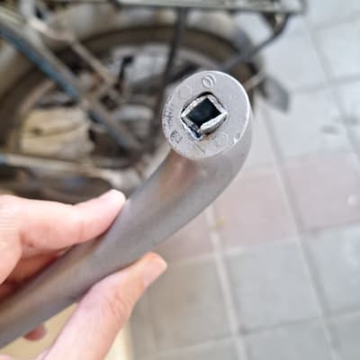 יד מחזיקה כלי עבודה ליד אופניים