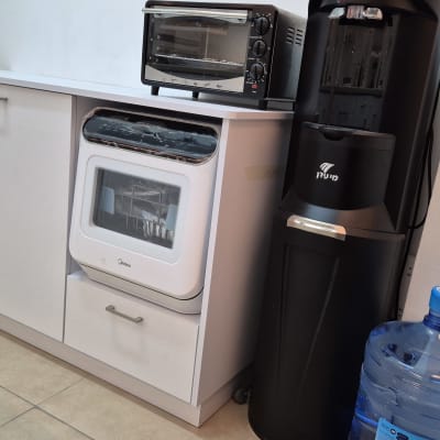 תנור קטן על ארון מטבח ליד מתקן מים