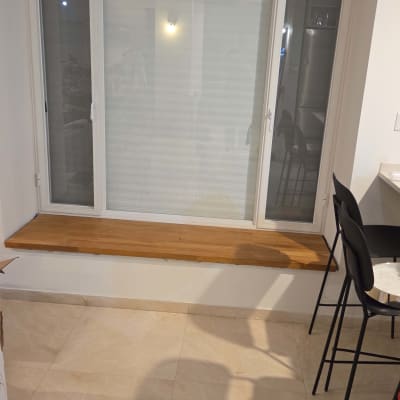 חלון עם ספסל עץ ורצפת אריחים