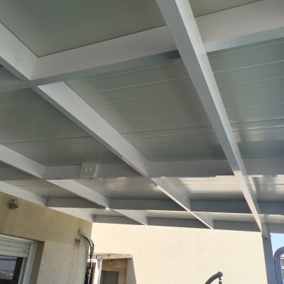 פרגולה מאלומיניום עם קורות ותקרה מחוברת לקיר
