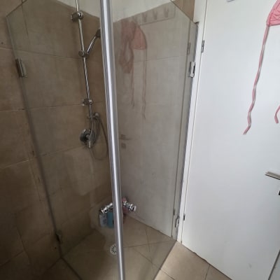 מקלחון זכוכית עם ראש מקלחת ודלת לבנה