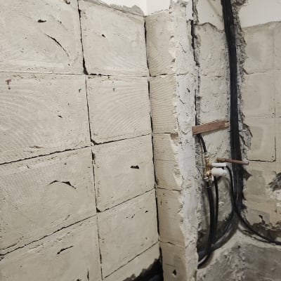 קיר בבנייה עם צינורות חשופים ועבודת טיח