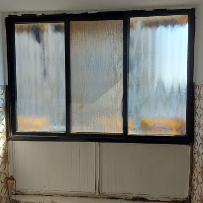 חלון זכוכית עם מסגרת שחורה ותבנית מטושטשת