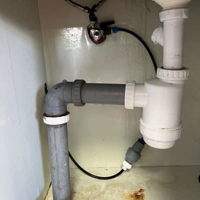 צנרת מתחת לכיור עם חיבורים וברזים