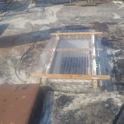 עבודת איטום על גג עם לוחות פלסטיק ועץ