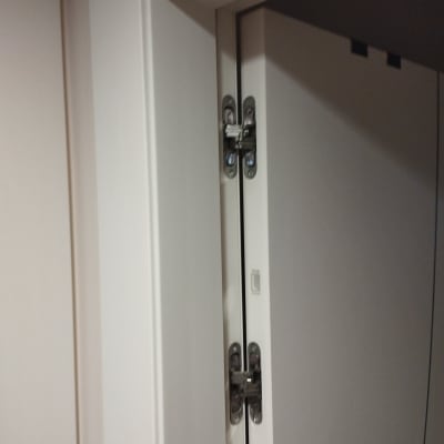 צירי דלת מתכתיים על דלת לבנה