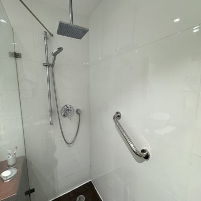 מקלחת עם ראש טוש ומעקה אחיזה