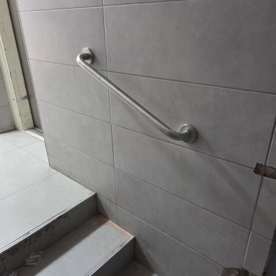 מעקה מתכת מותקן על קיר ליד מדרגות