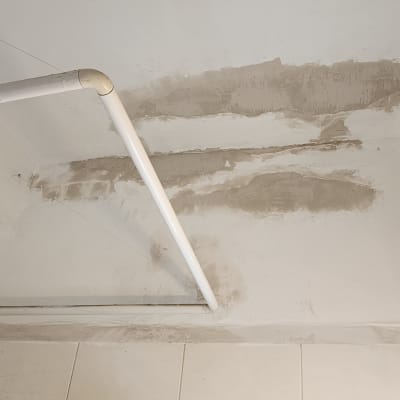 תיקוני טיח על תקרה עם צינור לבן