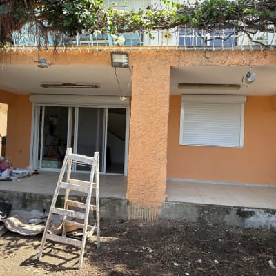 סולם צבעוני ליד קיר צבוע בצבע כתום