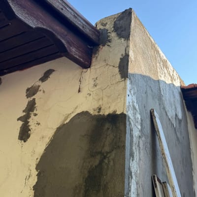 קיר מטויח עם תיקוני טיח, קרשים מונחים בצד