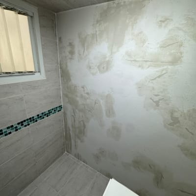 קיר עם תיקוני טיח בחדר אמבטיה