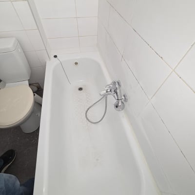 אמבטיה עם ברז ומקלחת בחדר רחצה