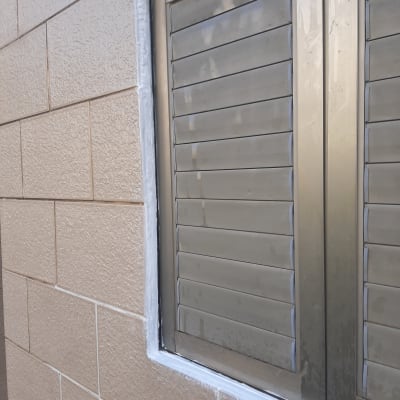 חלון אטום עם חומר איטום לבן סביב המסגרת