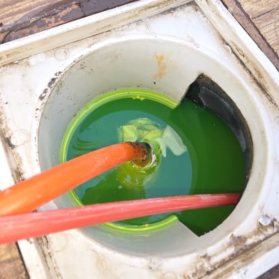 צינור עם נוזל ירוק בתוך פתח ניקוז